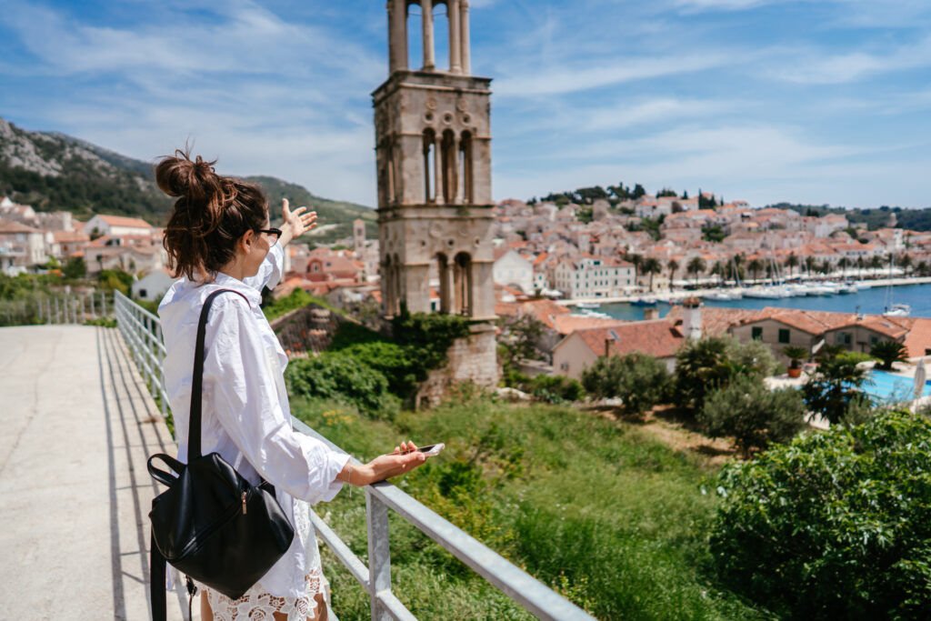 Young beautiful woman posing for the camera on the background of a small Croatian town