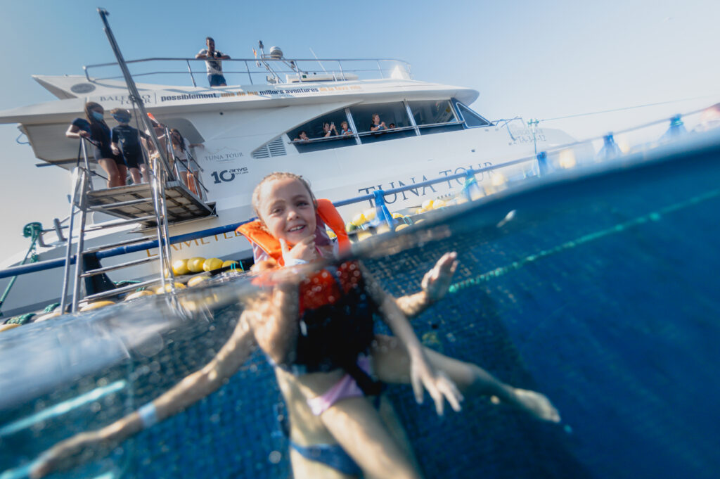 Nens nedant al costat del vaixell de Tuna Tour